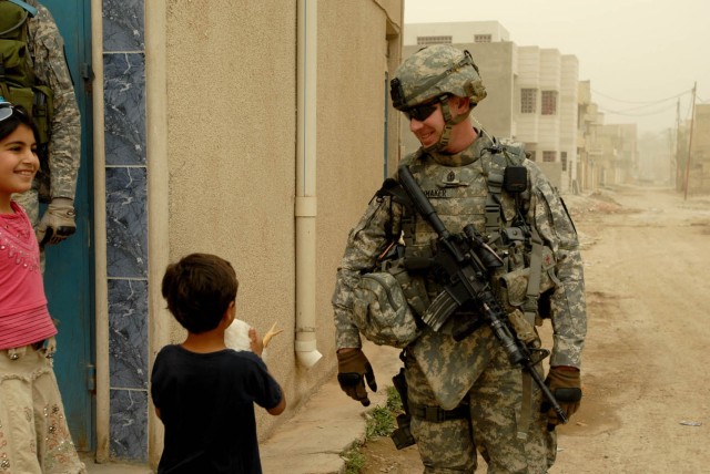 BAGHDAD - Waco, Texas native, 1st Sgt. John Shumaker (right), company first sergeant for Headquarters and Headquarters Company, 1st Battalion, 5th Cavalry Regiment, attached to the 1st Brigade Combat Team, 1st Cavalry Division jokes with a local...