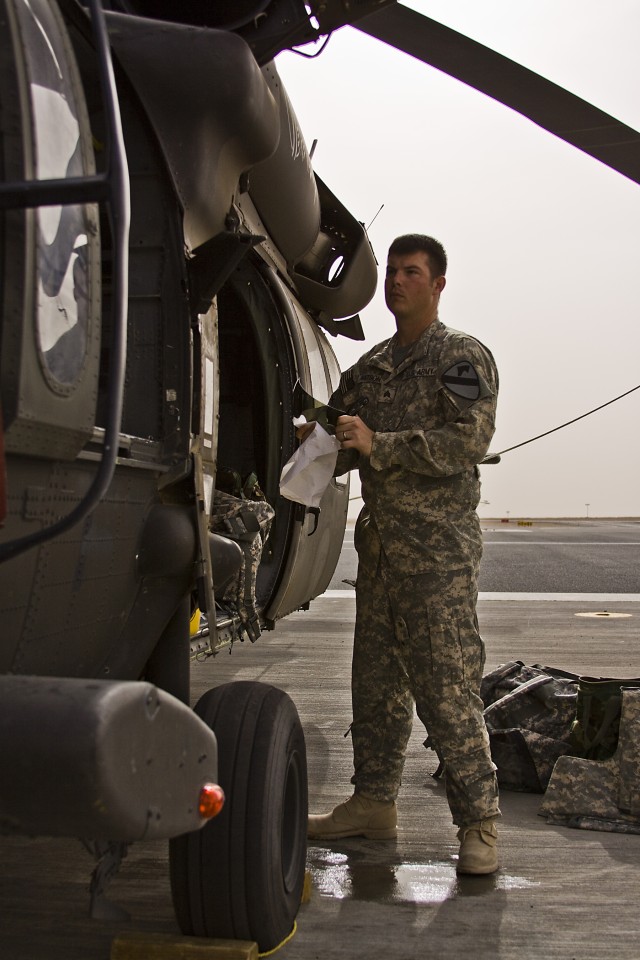 Before going out to complete the day time portion of dust qualification landings, Sgt. Dustin Watson, of Springdale, Ark., a UH-60 Black Hawk helicopter crew chief of Company A, 3rd Assault Helicopter Battalion, 227th Aviation Regiment, 1st Air...