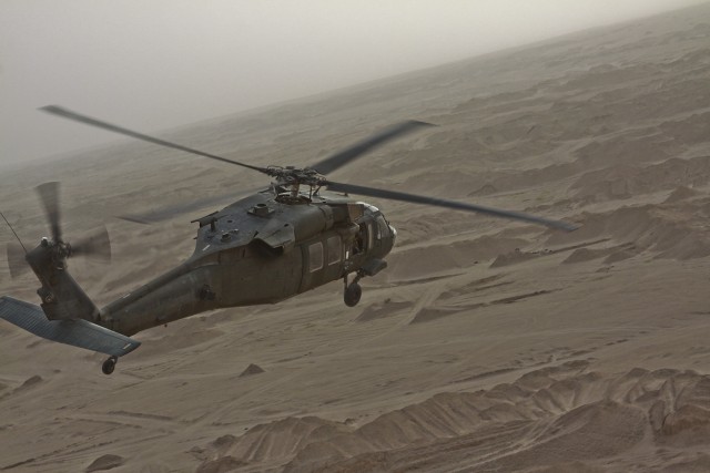 In the desolate landscape of Kuwait, the aircrew of a UH-60 Black Hawk helicopter from 3rd Assault Helicopter Battalion, 227th Aviation Regiment, 1st Air Cavalry Brigade, 1st Cavalry Division, scouts for a landing zone to conduct their dust...