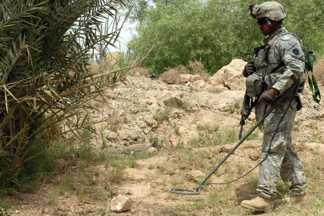 BAGHDAD – Columbus, Ohio, native, Spc. Wayne Mason, an infantryman assigned to the 56th Stryker Brigade Combat Team, uses a metal detector to sweep for weapons and explosives on a farm in Hay al-Skri here, May 8. “I came here to do my job and...