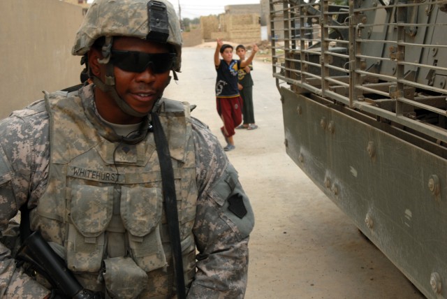 BAGHDAD – After shaking hands and giving candy to Iraqi children, Spc. Ronnie Whitehurst, an infantryman from Pensacola, Fla., assigned to C Troop, 2nd Squadron, 104th Cavalry Regiment, walks back to his Stryker vehicle in the streets of...