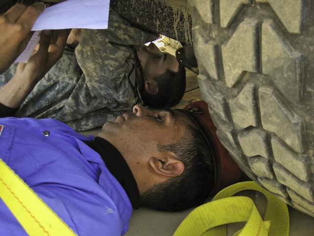 Spc. Matthew Atwood, a vehicle mechanic assigned to the 5th Battalion, 82nd Field Artillery Regiment, 4th Brigade Combat Team, 1st Cav. Div., from Bailey Miss., shows a Soldier from the Iraqi Army's 41st Brigade, 10th Division, what to look for under...