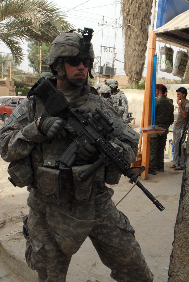 BAGHDAD - Kerrville, Texas native Spc. David Griffin, Battery A, 1st Battalion, 7th Field Artillery Regiment, pulls security in the Mutanabi  neighborhood of Baghdad Friday during a combined arms patrol with Iraqi Army soldiers. Griffin helped scour ...