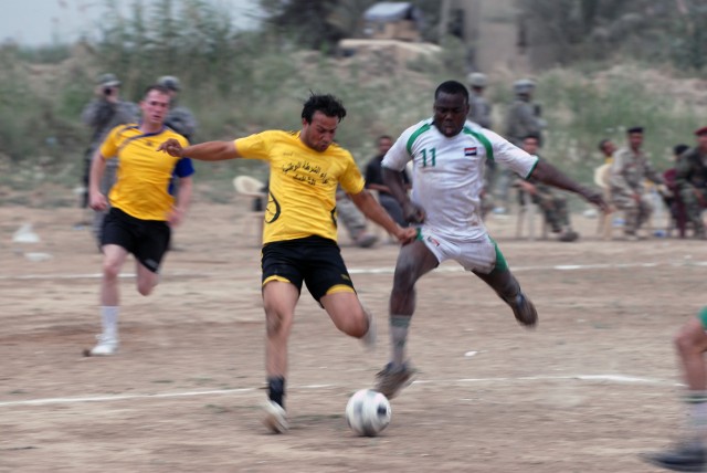 BAGHDAD -Pfc. Mark Skeen (right), from Jamaica, a scout with Headquarters and Headquarters Company, 1st Battalion, 505th Parachute Infantry Regiment, does his best to defend against a player from the 3rd Brigade, 1st National Police Division team...