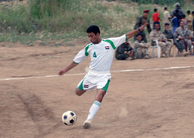 BAGHDAD - A Soldier with the 45th Iraqi Army Brigade takes a shot on goal during a preliminary match of the Combined Forces Football Tournament, May 10 in the community of Salman Pak. The game was played in sector to give the local population a...