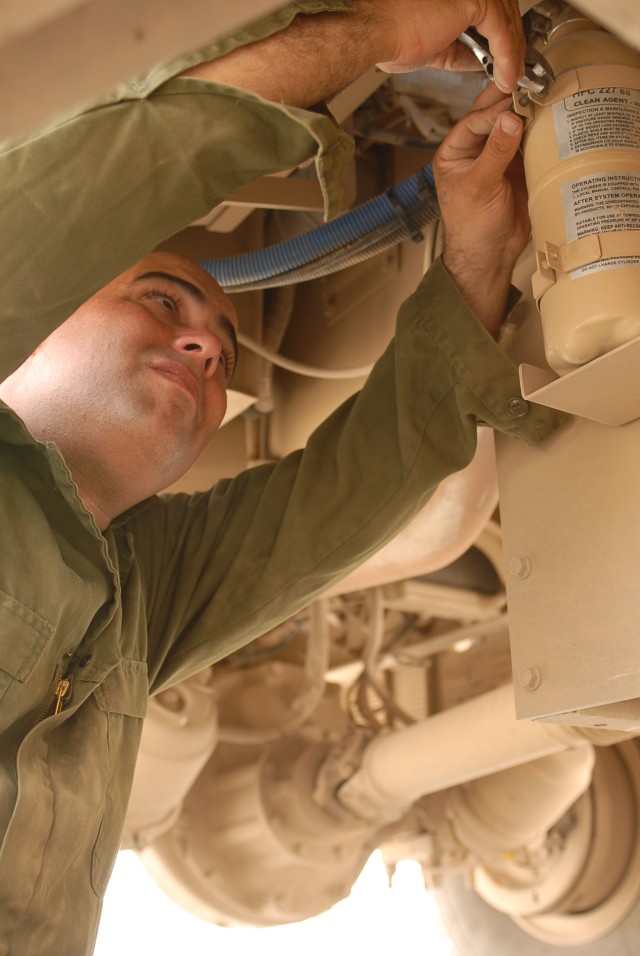 Spc. Tony Archer, a Porterville, Calif., native and a wheeled vehicle mechanic with Company B, 15th Brigade Support Battalion, 2nd Brigade Combat Team, 1st Cavalry Division, works on a Mine-Resistant Ambush-Protected Vehicle at the 15th BSB's...