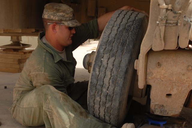 Spc. Jason Taylor, a San Antonio, Texas, native and a wheeled vehicle mechanic for Company B, 15th Brigade Support Battalion, 2nd Brigade Combat Team, 1st Cavalry Division, removes the tire of a trailer at 15th BSB's maintenance bay on Forward...