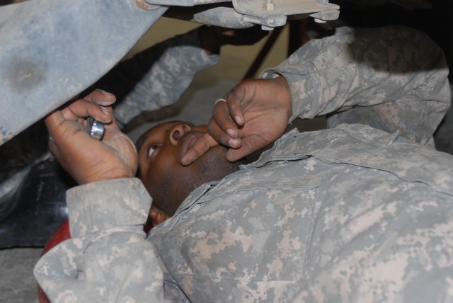 Pvt. Michael Gray, a Houston native and a wheeled vehicle mechanic for Company B, 15th Brigade Support Battalion, 2nd Brigade Combat Team, 1st Cavalry Division, works on the underside of a vehicle at 15th BSB's maintenance bay on Forward Operating...