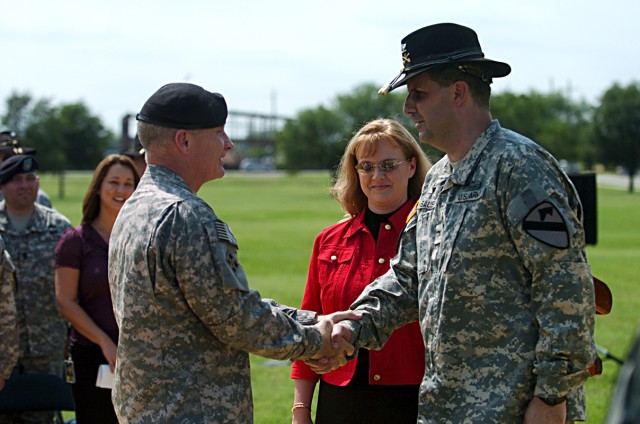 Maj. Gen. Jeffery Hammond, 4th Infantry Division (Mechanized) commanding general, congratulates newly promoted Col. Jeffrey Sauer, 1st Cavalry Division Rear Detachment commander, after he and Sarah Sauer pinned on his new rank May 4, in front of the ...