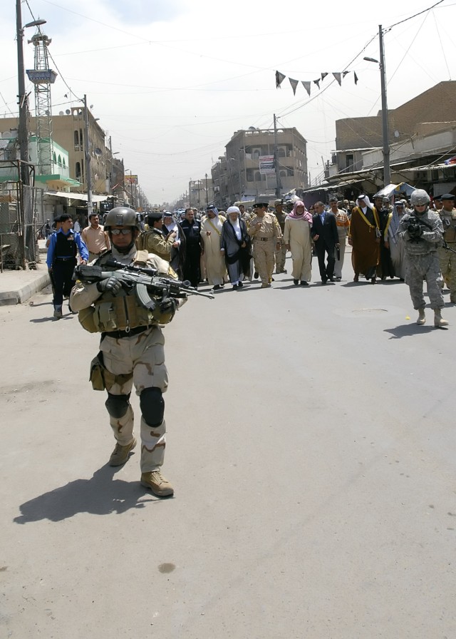 BAGHDAD - Members of the Iraqi Army and Soldiers serving with the 1st Combined Arms Battalion, 18th Infantry Regiment, 2nd Heavy Brigade Combat Team, 1st Infantry Division, Multi-National Division - Baghdad, walk a busy market street with civic,...
