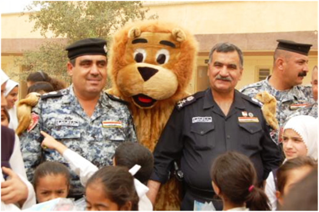 Brig. Gen. Borhan (right of lion), the inner city police chief of Kirkuk city, stands with the "Lion of Kirkuk" at a school delivery drop May 6 at the Halima al-Sadiya Primary School in the Qoria district of Kirkuk province, Iraq. The students of the...