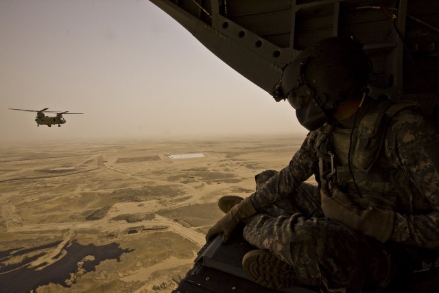 Sitting on the ramp of a CH-47F Chinook helicopter during a supply pick up, Spc. Mitchell Peterson from Buckeye, Ariz., a CH-47 Chinook crew chief in Company B, 2nd General Support Aviation Battalion, 227th Aviation Regiment, 1st Air Cavalry Brigade,...