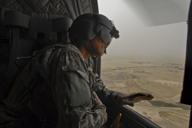 Sgt. Nicholas Jackson, from Concho, Ariz., a CH-47 Chinook helicopter flight engineer, Company B, 2nd General Support Aviation Battalion, 227th Aviation Regiment, 1st Air Cavalry Brigade, 1st Cavalry Division, observes the sandy Kuwaiti terrain while...