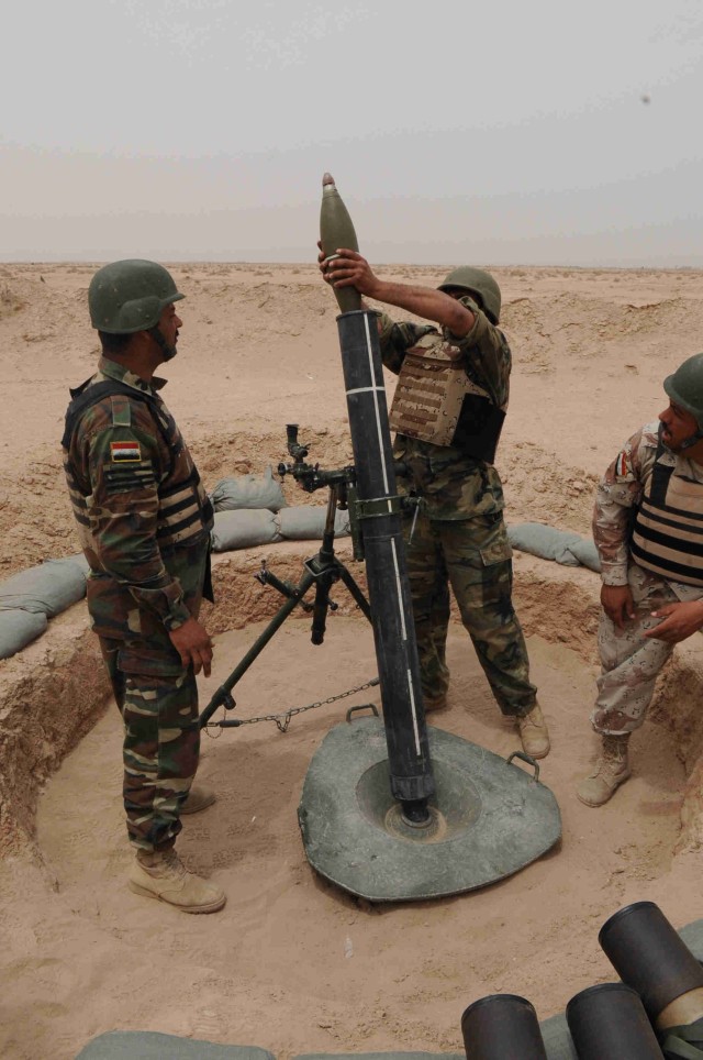 BAGHDAD - Iraqi Army soldiers assigned to 35th Iraqi Army Brigade, 9th Iraqi Army Division, "hang" a mortar round, May 8, during a training event at Joint Security Station Loyalty on the eastern edge of Baghdad. The soldiers along with...