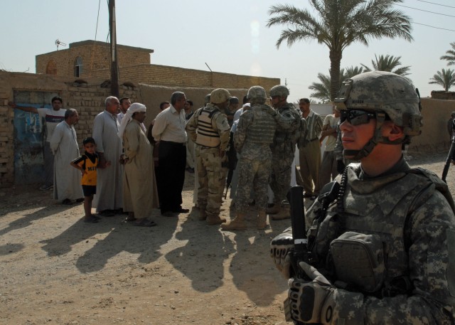 TAJI, Iraq - Philadelphia native, Spc. Keith Mason, a Soldier with Company A, 1st Battalion, 111th Infantry Regiment, 56th Stryker Brigade Combat Team, watches a street in Nadeem, west of Taji and just north of Baghdad, as an Iraqi Army Soldier...