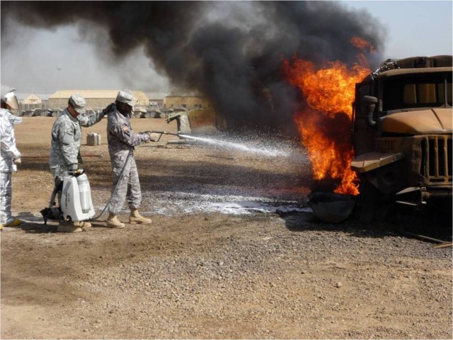 CAMP TAJI, Iraq-Pvt. 1st Class Efrain Santiago steadies Spc. Patrick Johnson during firefighter training at Camp Taji.  They are two of the Soldiers from Headquarters and Headquarters Troop, 1st "Garryowen" Squadron, 7th Cavalry Regiment, 1st...