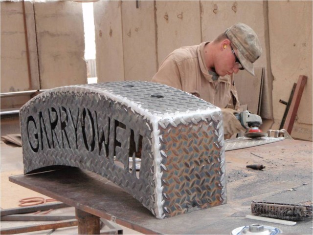 BAGHDAD-Spc. Thomas Springer, a track vehicle mechanic in Troop D, 1st "Garryowen" Squadron, 7th Cavalry Regiment, 1st Brigade Combat Team, 1st Cavalry Division, polishes a steel plate that will be placed behind the letters in a squadron's guidon...