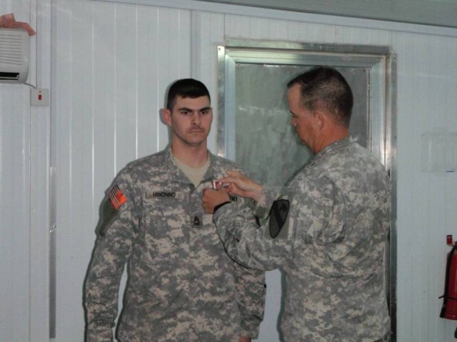 BAGHDAD-Command. Sgt. Maj. Mervyn Ripley (right) affixes the Meritorious Service Medal to Master Sgt. Greg Minonno's collar May 7, during a ceremony on Joint Security Station Isitqlal .  Master Sgt. Minonno received the award for his exceptional...