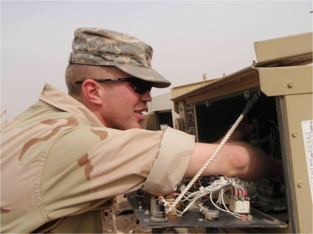 BAGHDAD-Spc. David Riha, a generator mechanic in Forward Support Troop D, 1st "Garryowen" Squadron, 7th Cavalry Regiment, the 1st Brigade Combat Team, and the 1st Cavalry Division, reaches into the compartment of a generator while conducting...