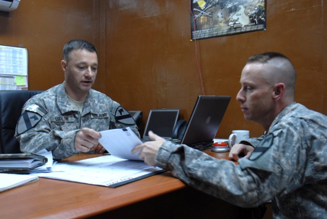 BAGHDAD - Sgt. Maj. Garrett Luplow (left), of Buffalo, N.Y., and Master Sgt. Jeff Helmes, of Denver, discuss Stop Loss Special Pay at the 1st Cavalry Division Retention Office. The Army is phasing out stop loss, which is the involuntary extension of ...