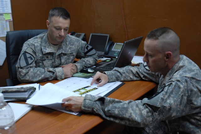 BAGHDAD - Sgt. Maj. Garrett Luplow (left), of Buffalo, N.Y., and Master Sgt. Jeff Helmes, of Denver, discuss Stop Loss Special Pay at the 1st Cavalry Division Retention Office. The Army is phasing out stop loss, which is the involuntary extension of ...