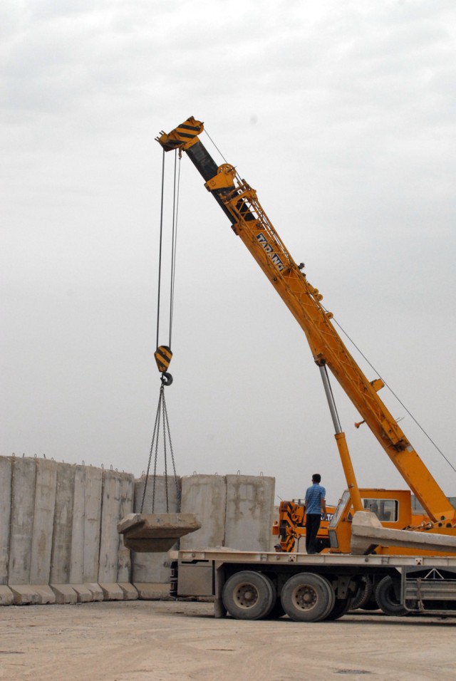 BAGHDAD - Iraqi contractors put up T-walls at Joint Security Station Ur, May 13.  T-walls have already been set up on the outer perimeter to secure the expanded part of the base. The JSS Ur will be a bigger base with more people because of the...
