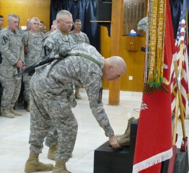 CAMP LIBERTY - Maj. Gen. Daniel Bolger, commander, Multi-National Division -Baghdad, places a 1st Cavalry Division coin on Spc. Jacob Barton's memorial display, after rendering honors, May 14.  Many other left tokens on the display which will be...