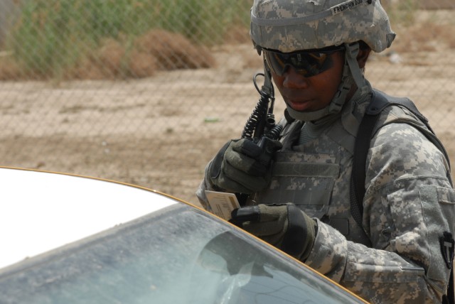BAGHDAD - Spc. Tiffany Frenchwood, a logistical specialist assigned to Apache Troop, 1st Squadron, 124th Cavalry Regiment, is the first line of security at Victory Base Complex here as she checks ID cards at an entry control point, May 14....