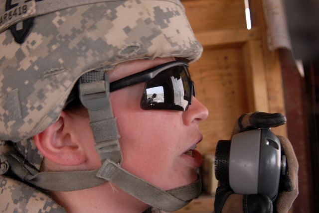 BAGHDAD - Fort Wayne, Ind. native, Spc. Janice Parisi, an intelligence analyst assigned to Apache Troop, 1st Squadron, 124th Cavalry Regiment, uses the microphone to give orders to vehicles entering her checkpoint at Victory Base Complex here, May...