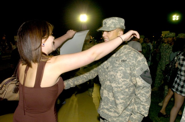 Cylia Amacker rushes out to be in the arms of Pfc. Ethan Amacker, 2nd Battalion, 7th Cavalry Regiment, 4th Brigade Combat Team, 1st Cavalry Division, during  a homecoming ceremony May 14, on Cooper Field in front of the division headquarters...