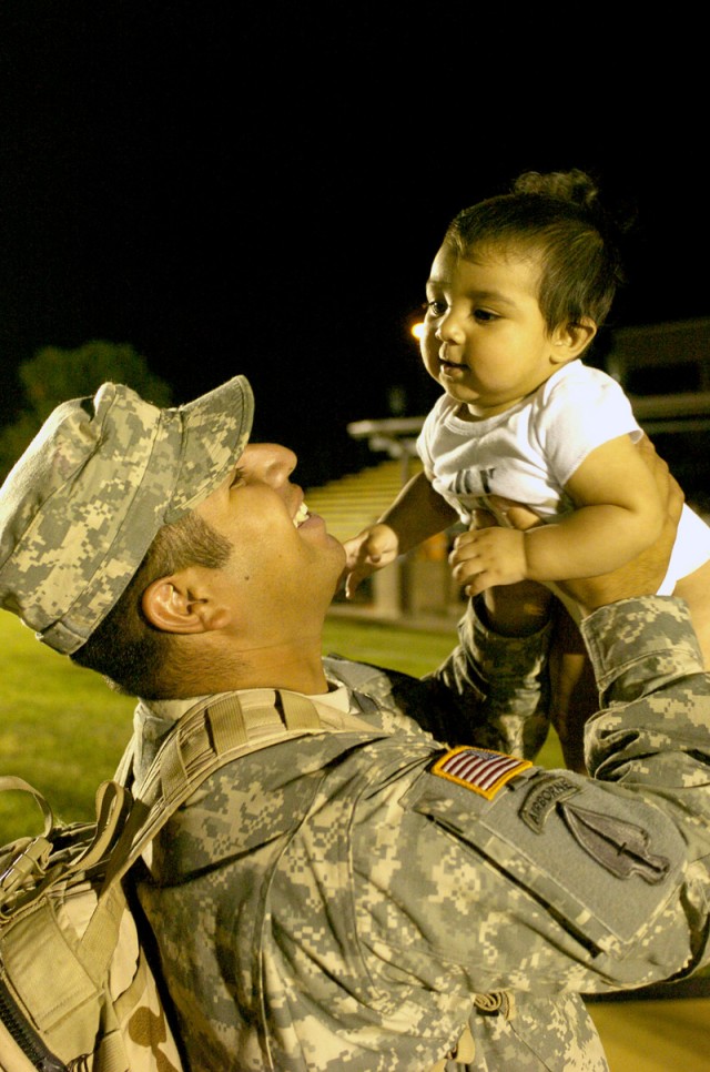 Spc. Miguel Meza, of Dinuba, Calif., lifts up his 7-month-old son, Angel, during a homecoming ceremony May 14, on Cooper Field, Fort Hood, Texas, as he and more than 200 other Soldiers from 4th Brigade Combat Team, 1st Cavalry Division, returned...