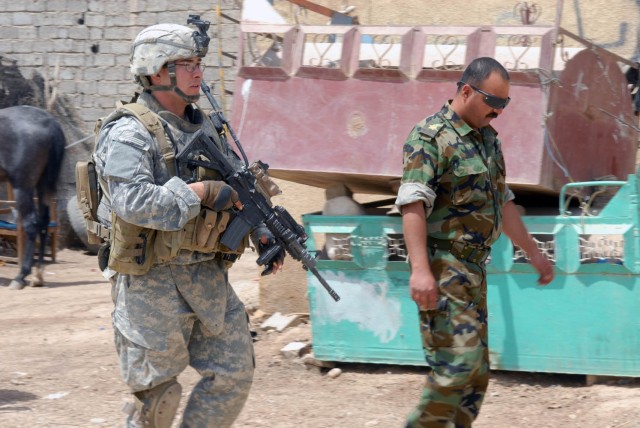BAGHDAD - Phoenix, Ariz. native, Cpl. Randon Berg, team leader for Company A, 2nd Battalion, 5th Cavalry Regiment, relays the route for the patrol to an Iraqi Army Soldier in Hamandiyah May 14.  All of the patrols conducted by the "Warriors" are...