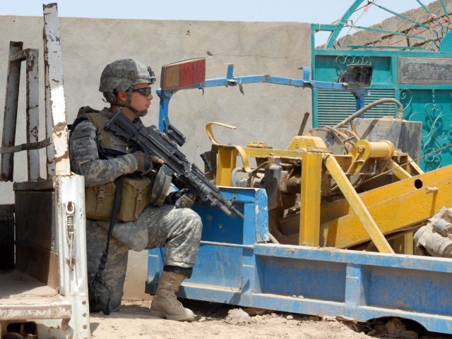 BAGHDAD - Worchester, Mass. Native, Pvt. Daniel Cesaitis, M-249 Squad Automatic Weapon gunner for Company A, 2nd Battalion, 5th Cavalry Regiment, pulls security while waiting for members of the partnered Iraqi Army before a joint patrol in...