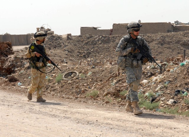 BAGHDAD - Northville, Mich. native, Spc. Carl Treen, a medic for Company A, 2nd Battalion, 5th Cavalry Regiment, patrols with his 3rd Battalion, 144th Brigade, 11th Iraqi Army Division partner during a joint patrol in Hamandiyah May 14.  The...