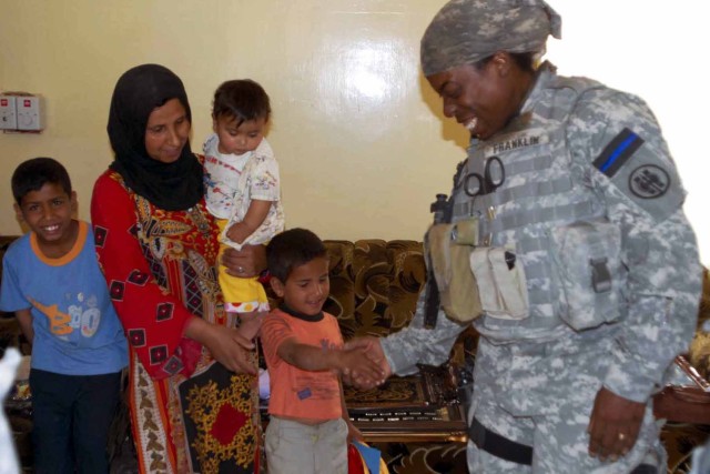 Demetria Franklin, a police officer from Sugar Land, Texas gives a boy in the western Mosul neighborhood of Al Rabin "some skin" after giving he and his family an assortment of school supplies and accessories. Franklin and the 302nd Military Police C...