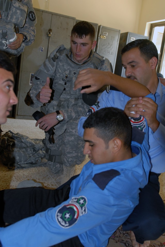 TAJI, Iraq -Spc. James Bagby, from Shelby N.C., an assistant medic assigned to 591st Military Police Company, 93rd MP Battalion, 8th MP Brigade, observes as Iraqi Police from the Tarmiyah Police Station treat bleeding on a mock casualty at Tarmiyah P...