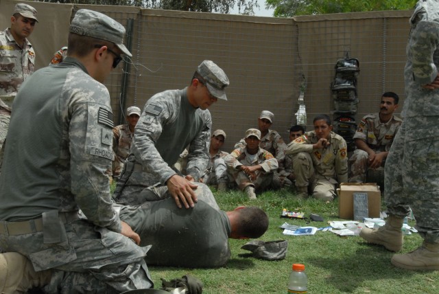 BAGHDAD -Staff Sgt. Jose Martinez (center) of Lebanon, Pa., rolls simulated casualty, Spc. Dean Matthews of Milton, Fla., to his side, May 17, as Cpl. Jason Rhoads of Oley, Pa. (at left) looks on. The Soldiers, from 2nd Battalion, 112th Infantry...