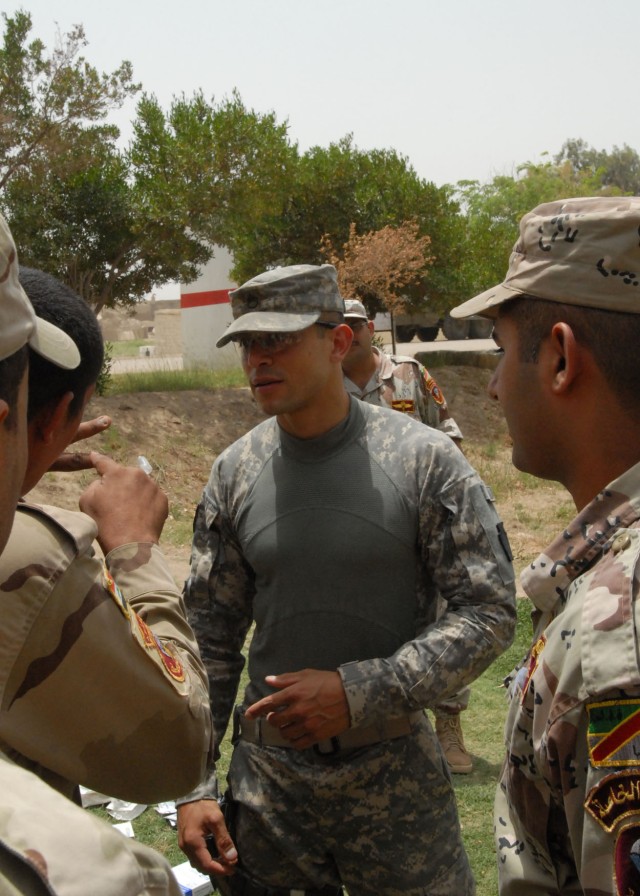 BAGHDAD- Pennsylvania Army National Guard medic, Staff Sgt. Jose Martinez (center), of Lebanon, Pa., and Iraqi Army Soldiers discuss the proper placement -between the second and third ribs - for a needle chest decompression during a combat...