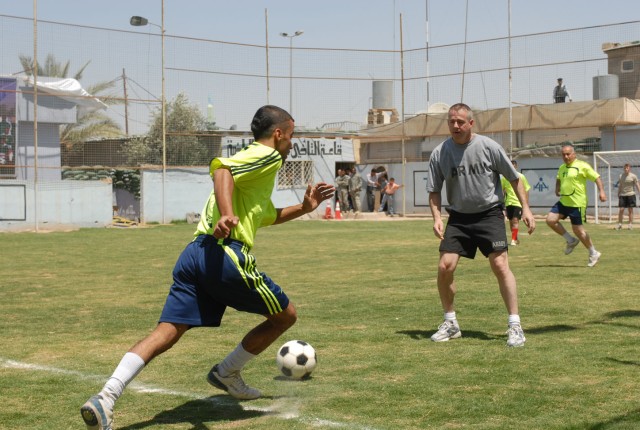 Lt. Col. Terry Cook (right), the commander of 3rd Battalion, 82nd Field Artillery Regiment, 2nd Brigade Combat Team, 1st Cavalry Division, faces off against an Iraqi police officer during a soccer match at an IP station in Kirkuk city, Iraq, May...