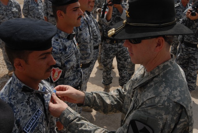 Lt. Col. Terry Cook, the commander of 3rd Battalion, 82nd Field Artillery Regiment, 2nd Brigade Combat Team, 1st Cavalry Division, pins a U.S. Army Achievement Medal to the uniform of an Iraqi Emergency Services Unit policeman, at the ESU Station...