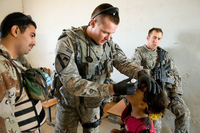 Sgt. Craig Wayman (center) and 1st Lt. Alexander Wener (right), from C Troop, 4th
Battalion, 9th Cavalry Regiment, 2nd Brigade Combat Team, 1st Cavalry Division
perform a medical checkup on an Iraqi child during a combined engagement with
medics from...