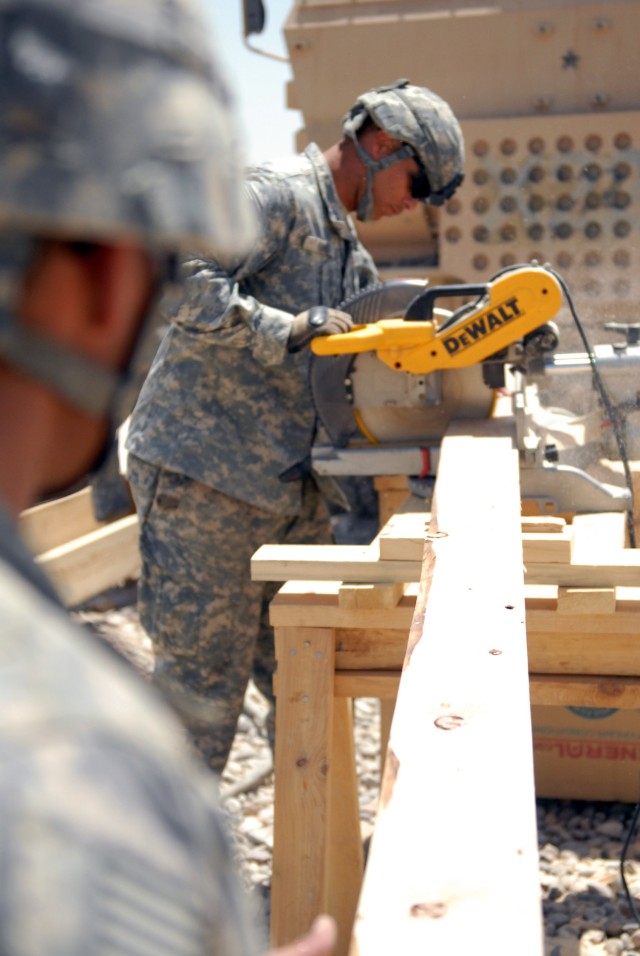 BAGHDAD - Spc. Joseph King, of Monterey, Calif., a member of the 46th Engineer Battalion, 225th Engineer Brigade, 1st Cavalry Division, runs one of two cut stations on the construction site, for floor systems, walls, and trusses for B-Huts at Combat ...