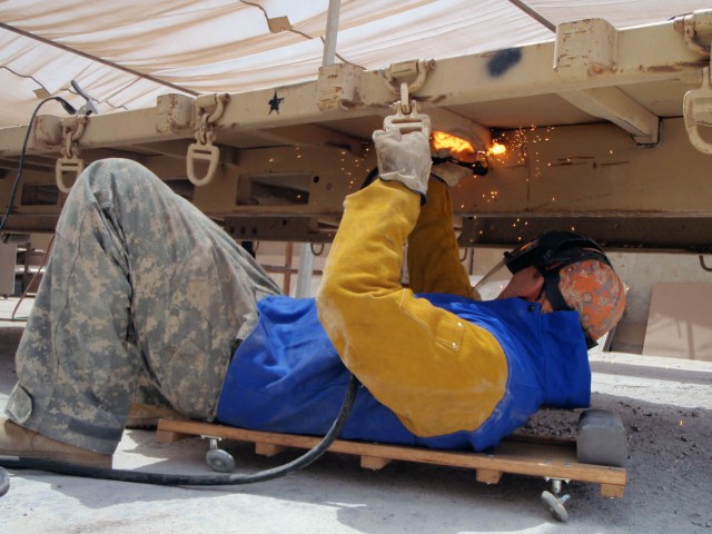 BAGHDAD-Globe, Ariz native, Sgt. Nathan Henderson, a welder for Troop D, 1st Squadron, 7th Cavalry Regiment, 1st Brigade Combat Team, 1st Cavalry Division, cuts warped steel away from a "flat rack" cargo frame in an effort to replace weak metal at...