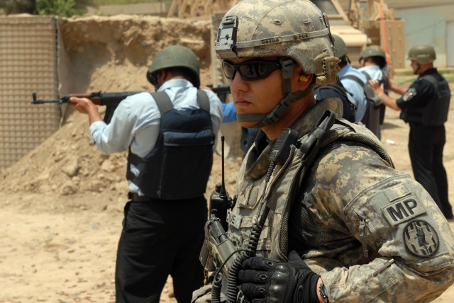 BAGHDAD - Sgt. Brandon Roque, a police transition team chief assigned to the 300th Military Police Company, 91st MP Battalion, 8th MP Brigade, watches as the Iraqi Police he trained administer a firing range at Joint Security Station Shuleik,...