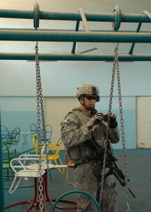 BAGHDAD - Lt. Michael Keckler, of Bel Air, Md., a platoon commander with Company B, 2nd Battalion, 112th Infantry Regiment, 56th Stryker Brigade Combat Team, photographs a room of a building formerly used as a school during a May 19 search for...