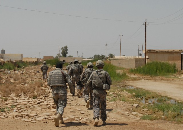 BAGHDAD - An interpreter and Soldiers of Company B, 2nd Battalion, 112th Infantry Regiment, 56th Stryker Brigade Combat Team, move through an Abu Ghraib neighborhood, May 19, during a search for explosives in Abu Ghraib. Pennsylvania Army National...