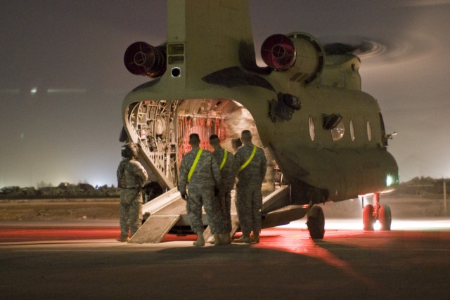 CAMP TAJI, Iraq—A group of Soldiers from the 1st Air Cavalry Brigade, 1st Cavalry Division, Multi-National Division—Baghdad, prepare to guide newly arrived comrades off a CH-47F Chinook helicopter which transported them to Camp Taji, May 20...