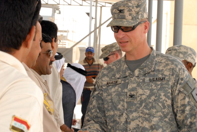 BAGHDAD - Col. Joseph Martin, from Dearborn, Mich., commander of 2nd Brigade Combat Team, 1st Infantry Division, greets local leaders before the Ghazaliyah improvement ceremony, May 20.  Martin attended the ceremony to honor the improvements made by ...