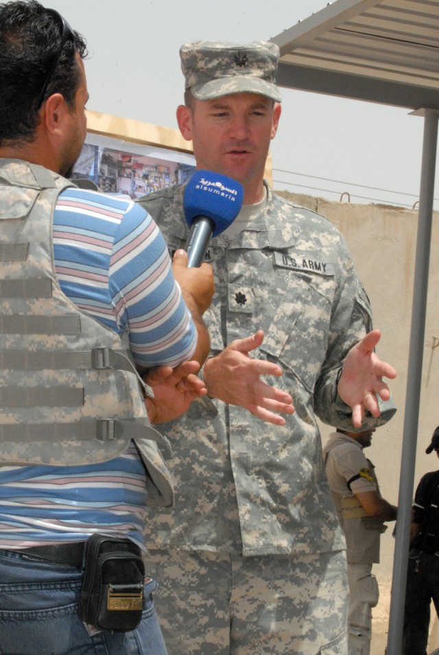 BAGHDAD - Lt. Col. John Richardson, of Tallahassee, Fla., commander of 5th Squadron, 4th Cavalry Regiment, 2nd Brigade Combat Team, 1st Infantry Division, speaks with an Iraqi reporter, May 20, about the improvements made in Ghazaliyah.  "We are not ...