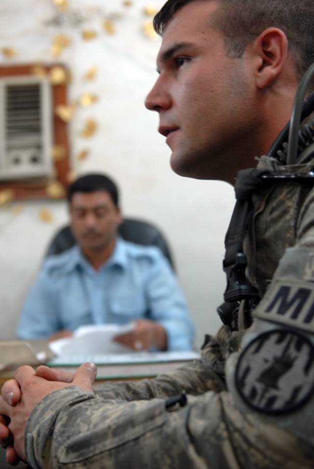 BAGHDAD - Sgt. Jordan Talbert, a military policeman and team leader from Washington, Ind., assigned to the 300th MP Company, 91st MP Battalion, 8th MP Brigade, discusses a supply tracking system for Adamiyah District Iraqi Police Station with Ragi...